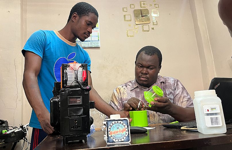 Young Sierra Leonean innovator Oswald Dunda assembling his lamp in his workshop.