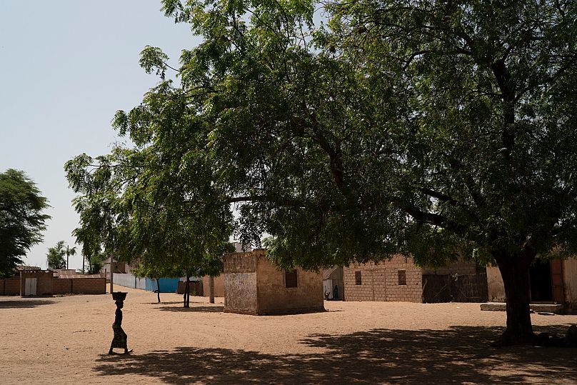 A girl carries a bucket of water from a community well in the village of Ndiawagne Fall in Kebemer, Senegal, on Friday, Nov. 5, 2021. 